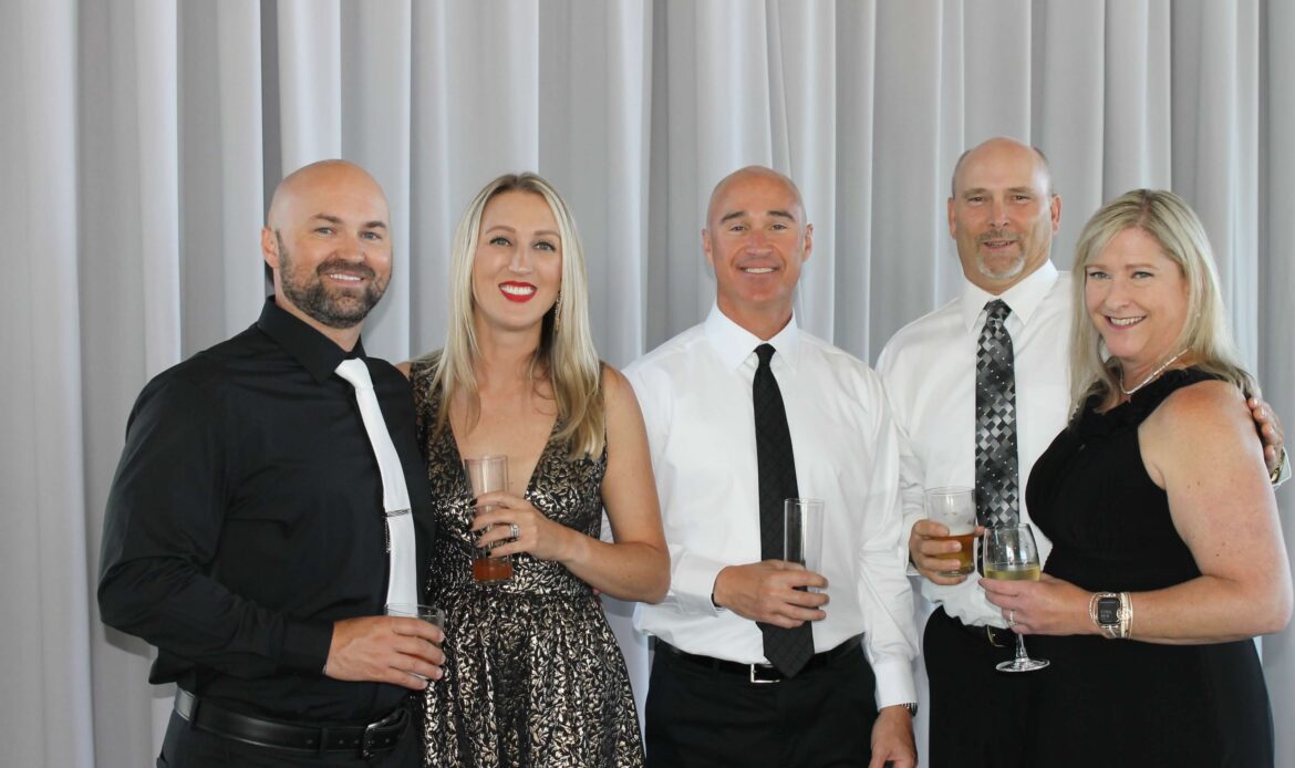 Five people smiling at a black tie event