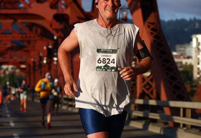 A man in marathon race with ear phone plugged in his ear