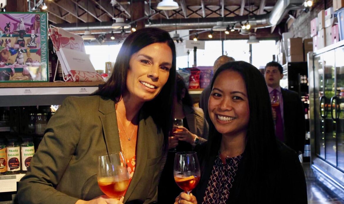 Image of two people smiling and drinking wine