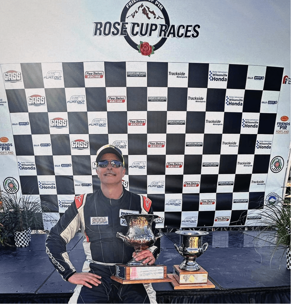 An image of a man holding a Rose Cup Trophy